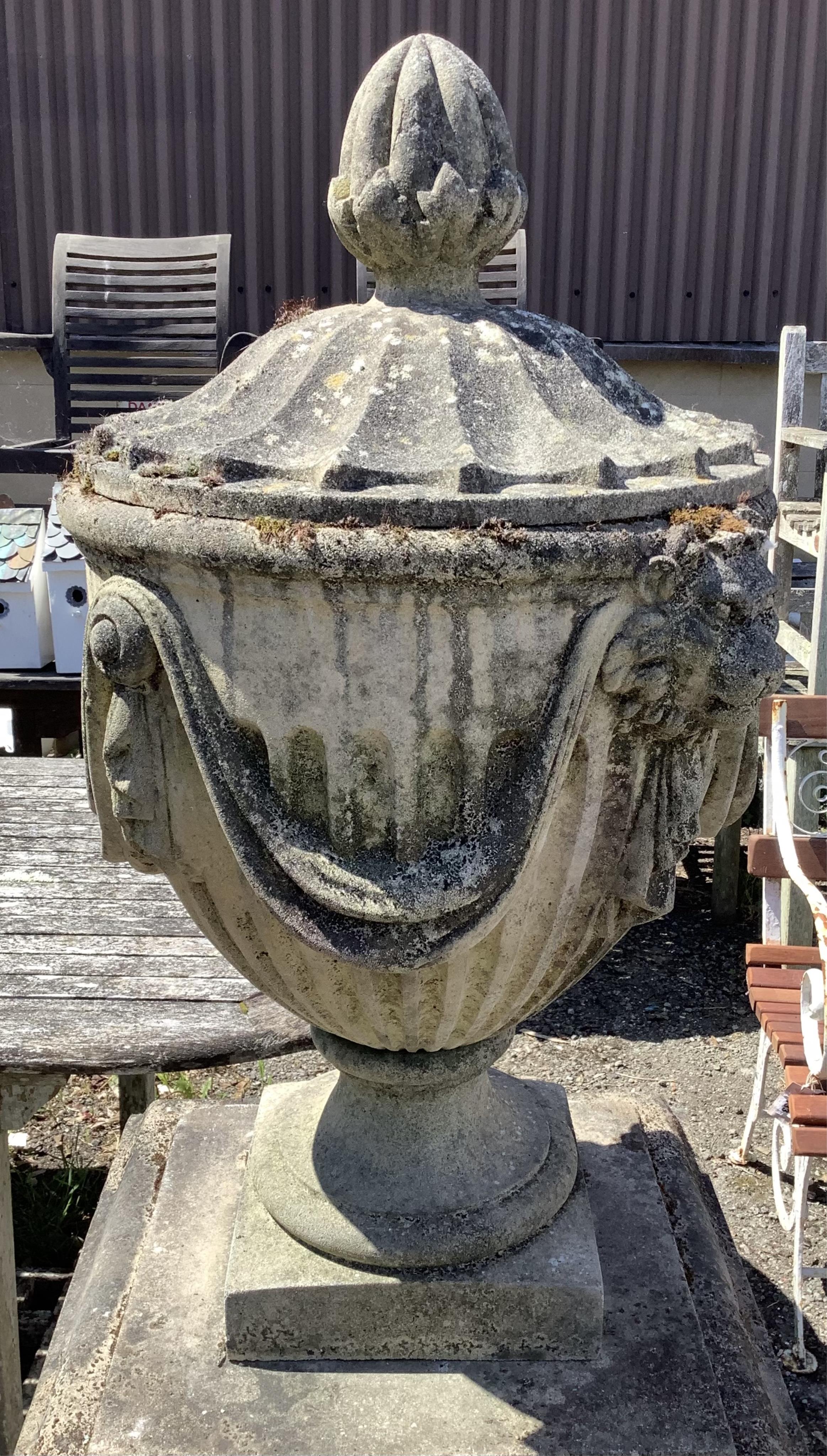 A reconstituted stone Adam style lidded garden urn on a square pedestal base, height 160cm